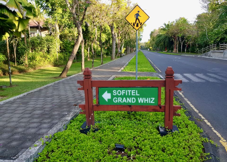 A green sign with an arrow pointing to the left to Sofitel and Grand Whiz.
