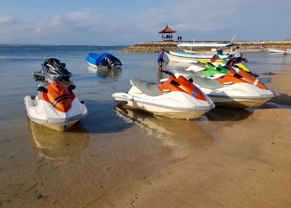 jet skis sit on the shore.