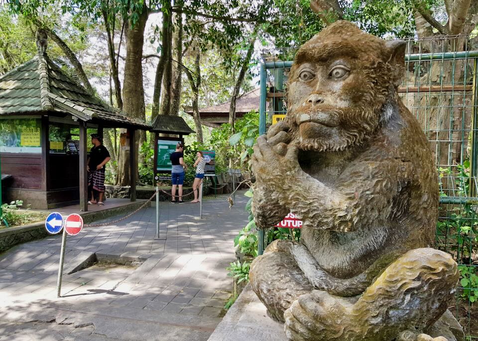 A large stone monkey statue sits outside of the Monkey Forest sanctuary.