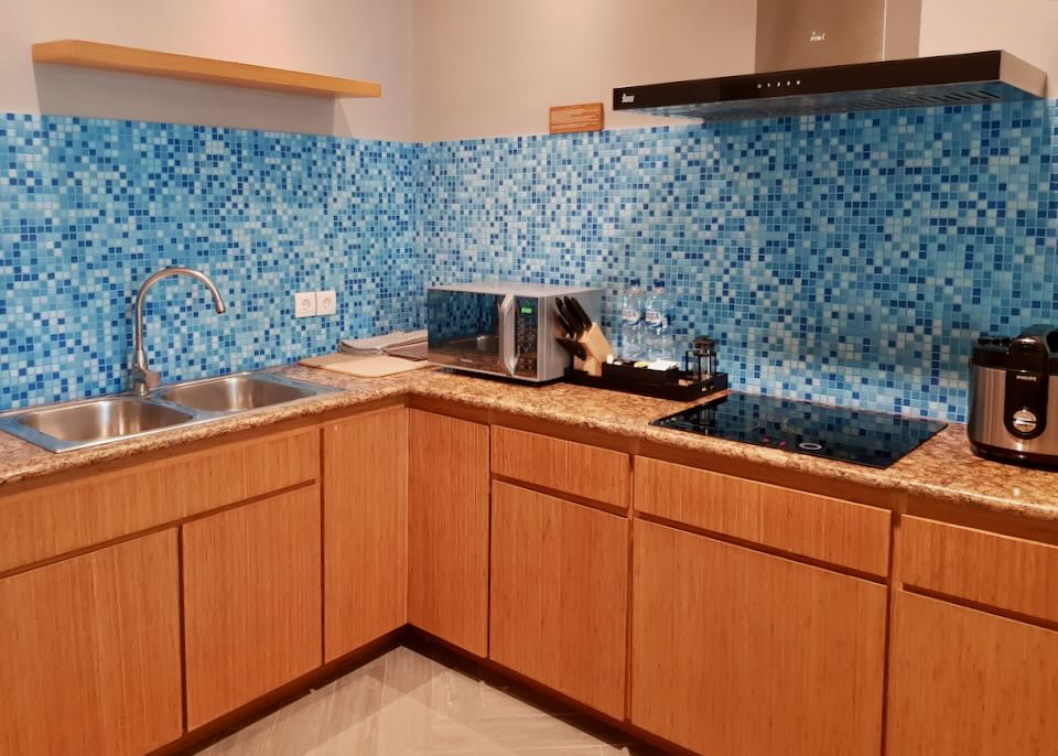 A blue tiled backsplash lines the kitchen wall.