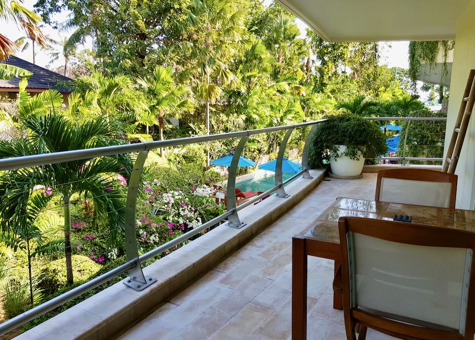 A table sits on a balcony overlooking the pool.