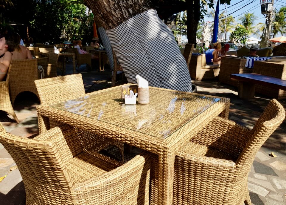 A whicker table sits outside a restaurant.