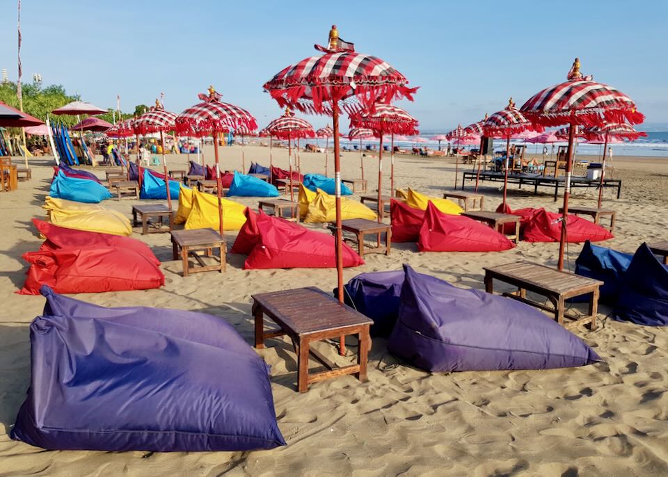 colorful beanbags sit on the beach.