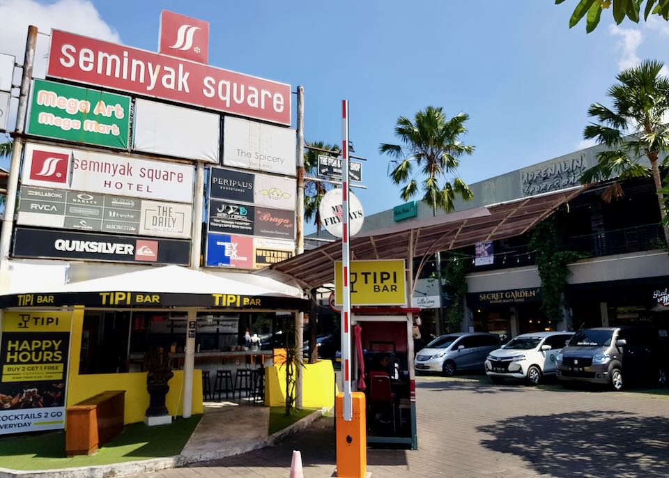 A Seminyak Square sign with a list of stores included.
