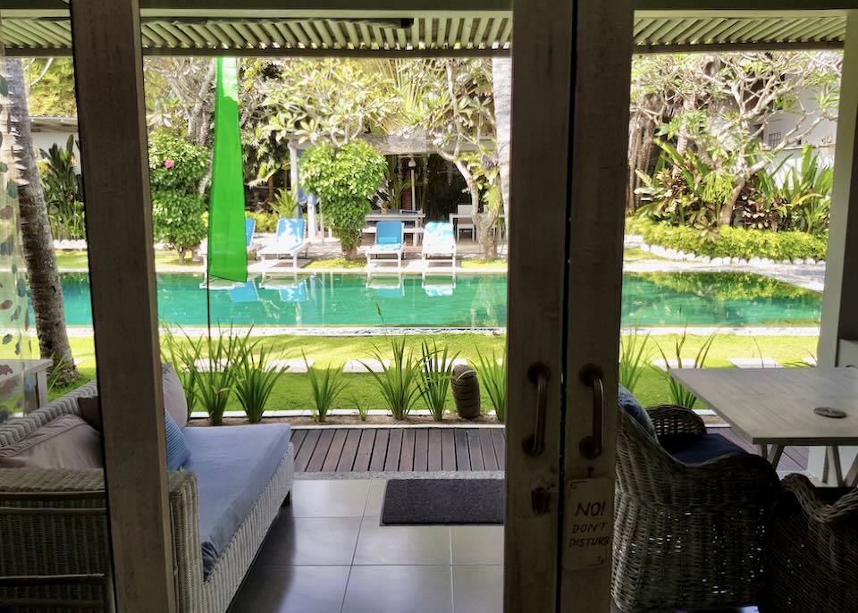 The colorful blue pool is seen through the outside doors in the resort room.
