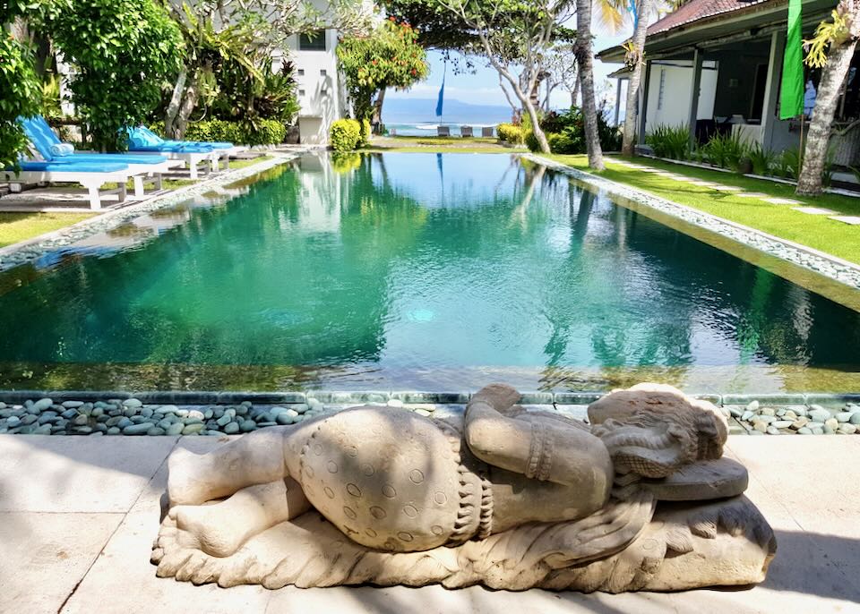 A sculpture of a lounging woman sits at one end of the pool.