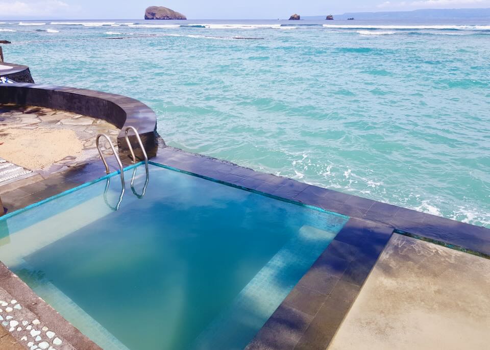 A small square pool overlooks the ocean.