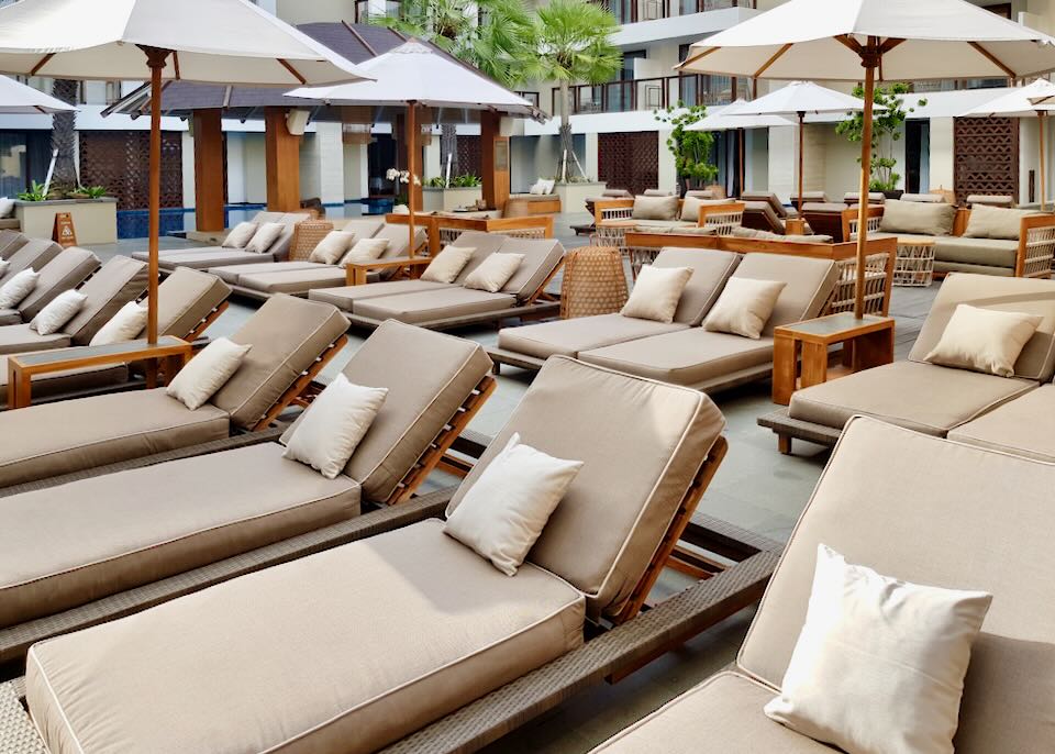 Many lounge chairs sit on the patio.