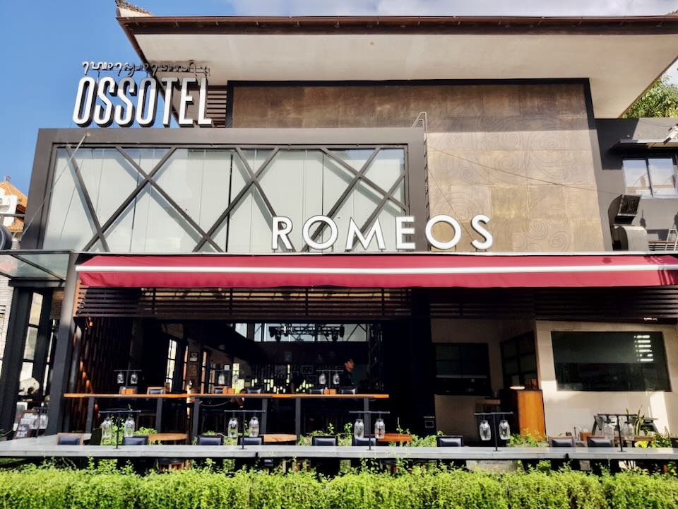An outdoor restaurant with a sign that reads, Romeos.