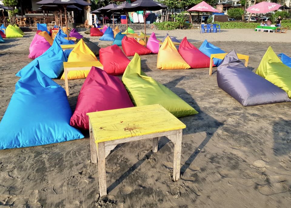 Colorful beanbags sit on the beach.