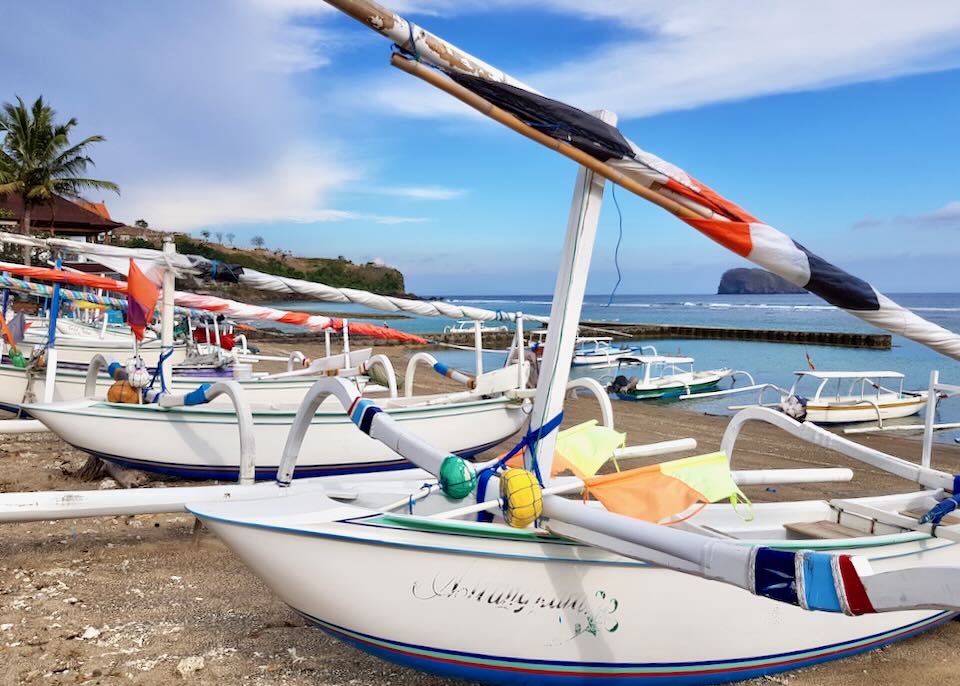 Small colorful boats sit on the shore.