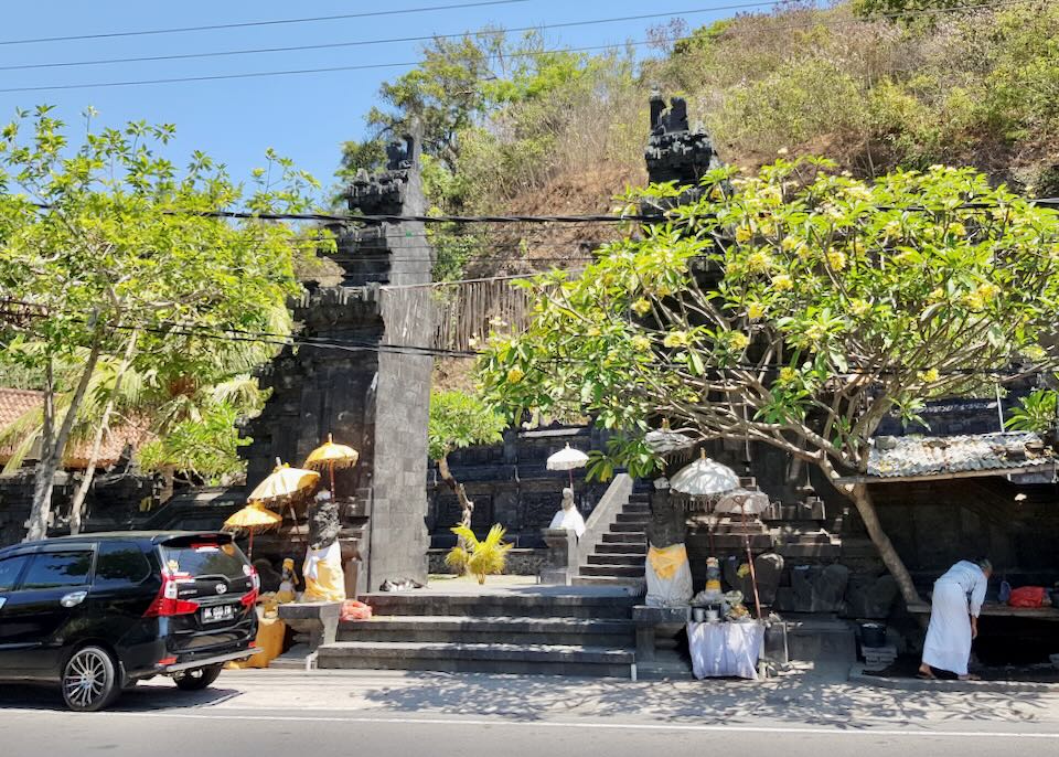 A temple with yellow and white umbrellas along a road.