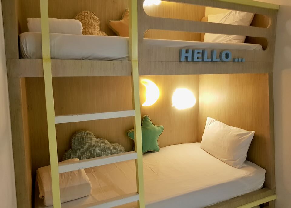 A bunk bed with moon lights, star pillows, and a yellow ladder.