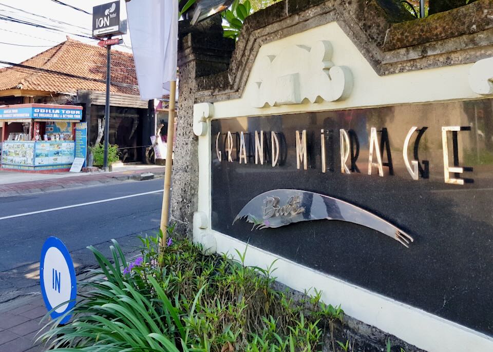 A shiny metal sign reads, "Grand Mirage, Bali"