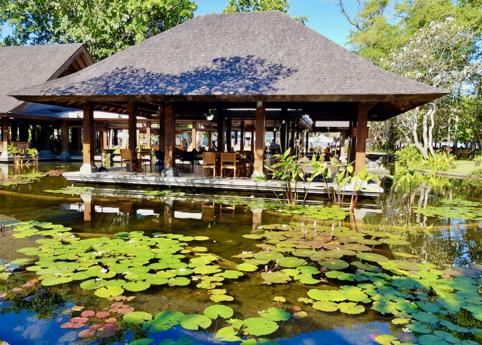 An open-air restaurant is surrounded by a Lily pond.