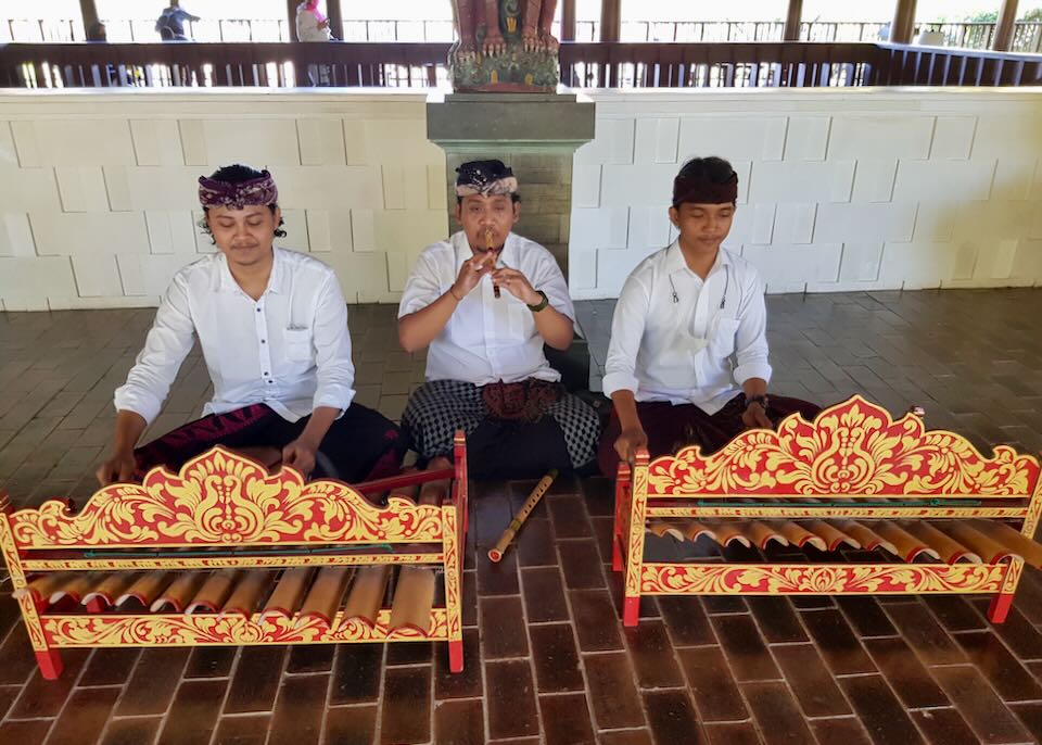 Musicians play a flute and bamboo xylophones on the floor of the lobby.