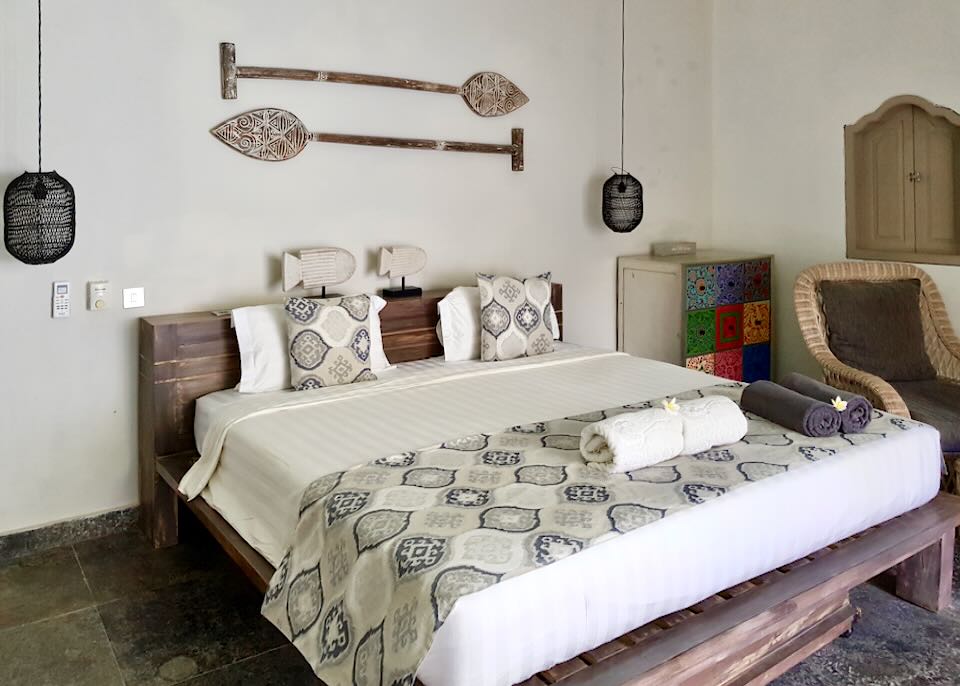 A bed with wood carved paddles above it.