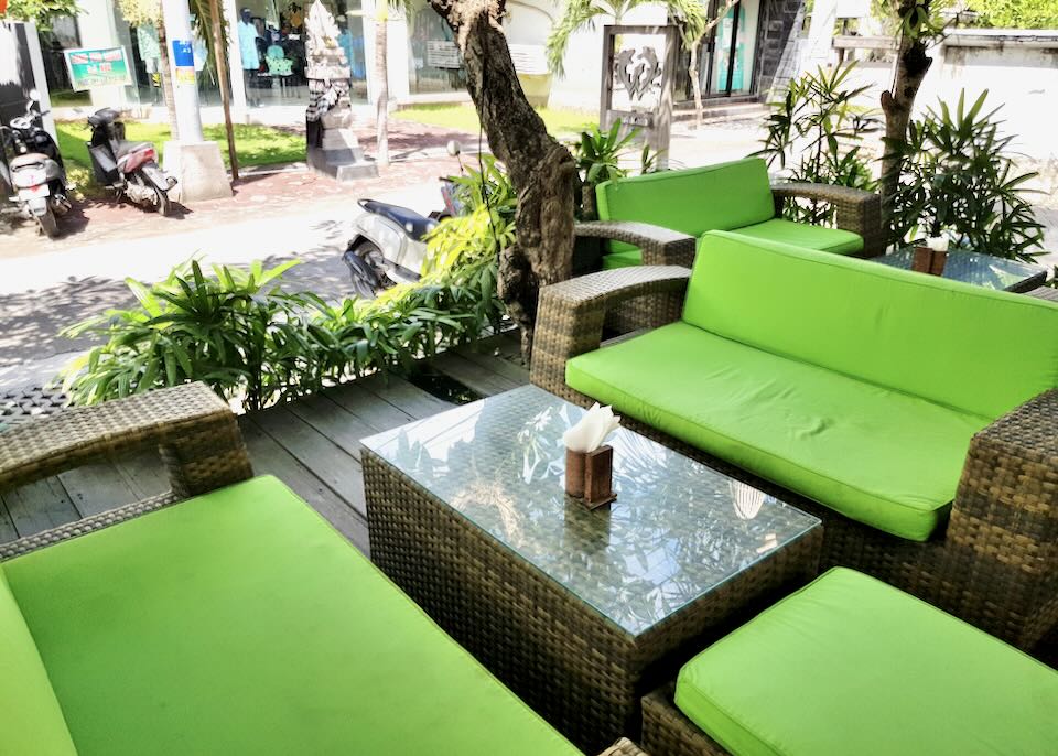 Lime green cushions adorn whicker furniture at and outside cafe.
