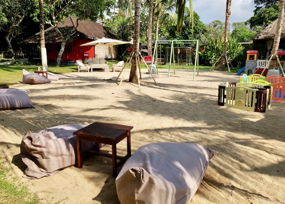 Beanbags and a swing set sit on the sand.