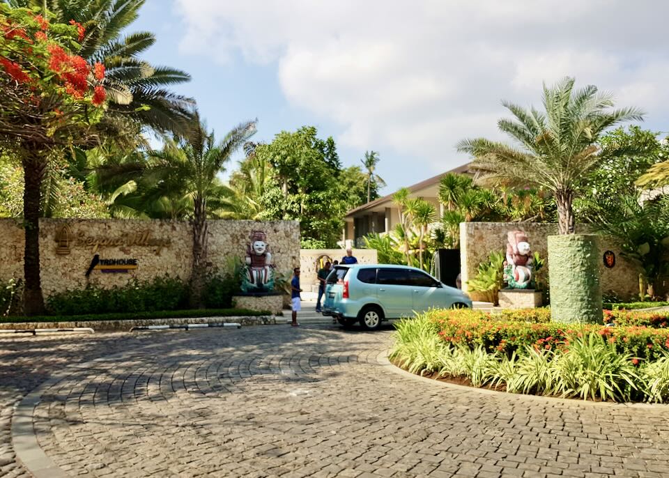 A small car parks in the circle drive outside the resort.