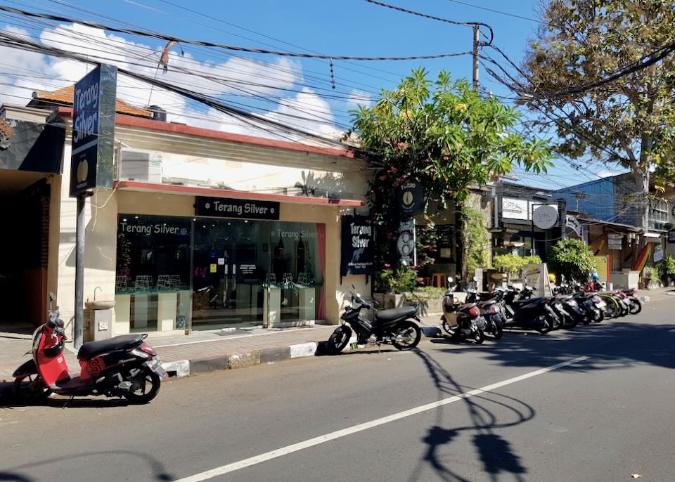 motorcycles sit parked on the side of the street.