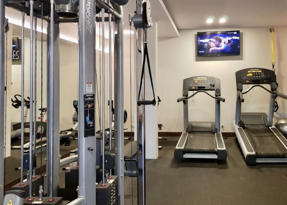 Treadmills and weight machines sit in a workout room.