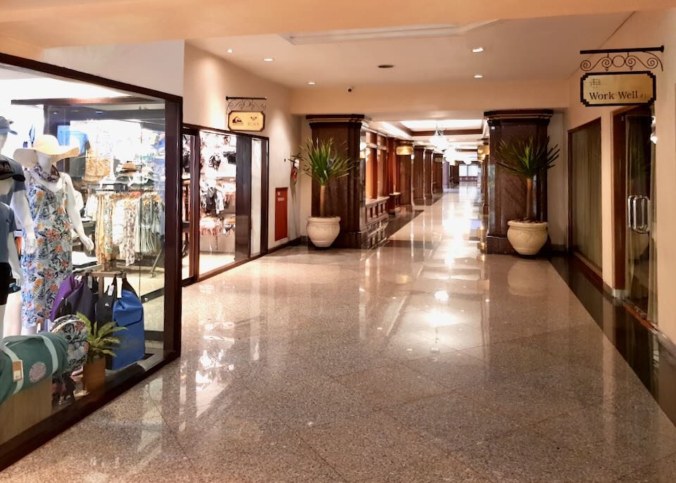 A marble hallway leading to stores.