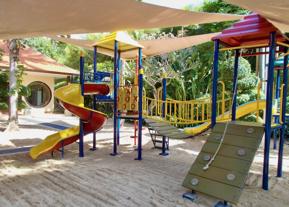 A children's play ground sits on a sand pit in the garden.