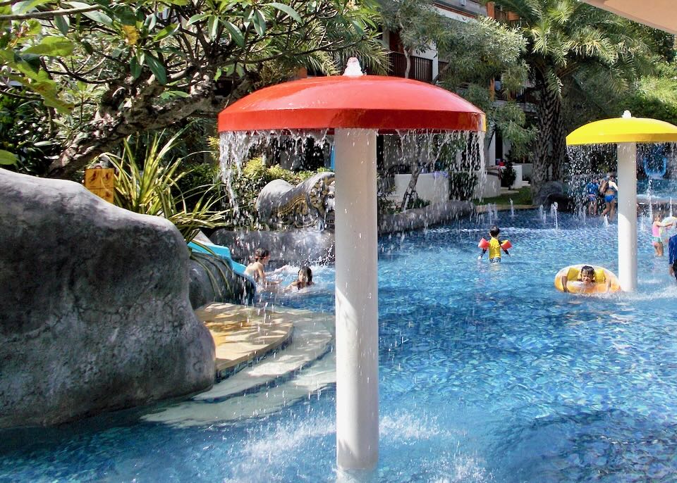 Kids swim under fountains at Padma Resort in Bali.
